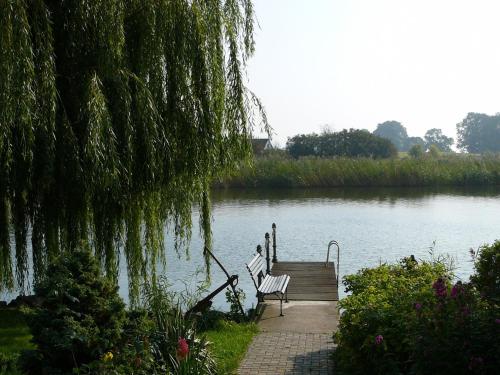 a bench sitting on a dock next to a lake at Spacious appartment in Wilhelmshof near Lake in Wilhelmshof