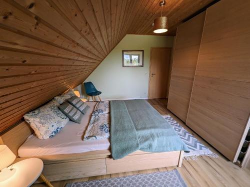 a bed in a room with a wooden ceiling at Spacious appartment in Wilhelmshof near Lake in Wilhelmshof