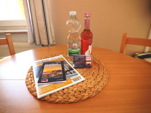 a table with a book and two bottles of alcohol at Spacious appartment in Wilhelmshof near Lake in Wilhelmshof