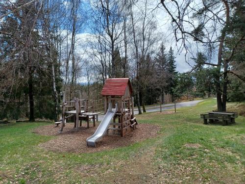 a playground in a park with a slide and a bench at Ferienhaus in der Nähe der Skipiste in Stadlern