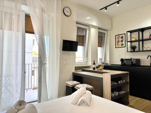 a living room with a kitchen with a table and a clock at My Room Centrale e Moderno Appartamento in Bari