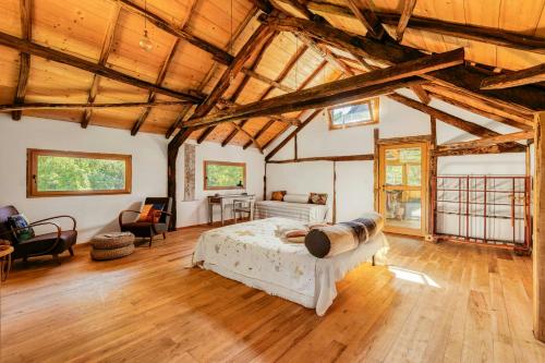 a bedroom with a bed in a room with wooden ceilings at Natural Riverside Retreat In Tiglieto in Tiglieto