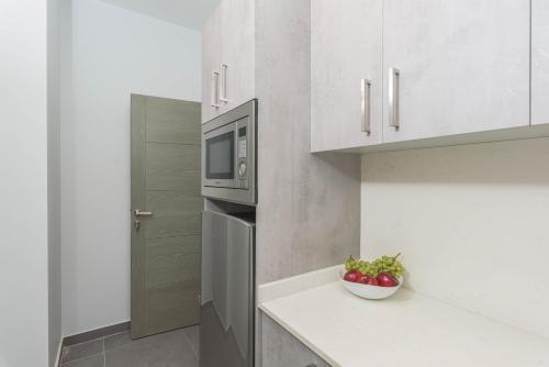 a kitchen with a refrigerator and a bowl of apples at Grey - Elegant Apartments in Awkar in Dbayeh