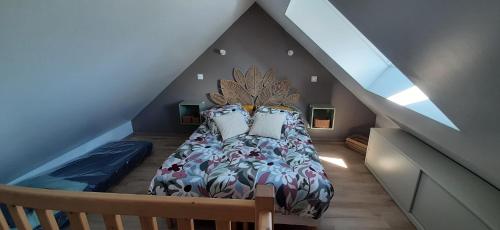 a bedroom with a bed with pillows in a attic at La Péra in Putanges