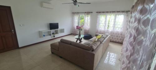 a living room with a couch and a vase of flowers at Royale Green Villa in Anse Royale