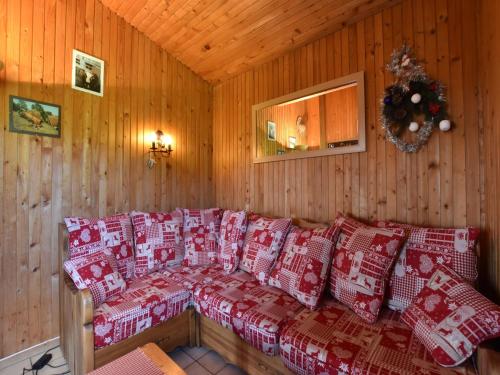 a room with red and white pillows on a couch at Chalet in Saulxures near Ski Resorts in Saulxures-sur-Moselotte