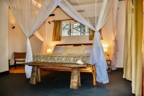 a bedroom with a bed with a canopy at Salty's Kitesurf Village in Kilifi
