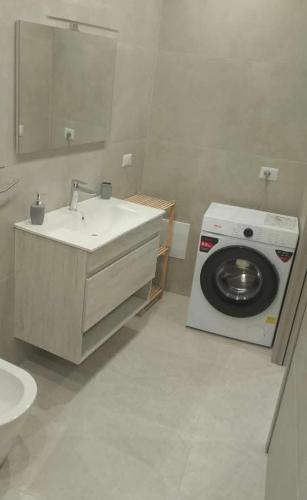 a bathroom with a sink and a washing machine at Thysia in Conversano