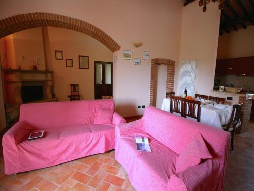 - un salon avec des canapés roses et une table dans l'établissement Lovely Farmhouse in Asciano with Swimming Pool, à Asciano