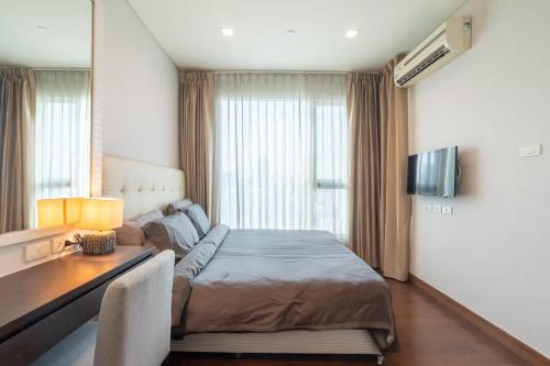 バンコクにあるIvy Thonglor Luxury Condo with Swimming Pool, Fast Wifiのベッドと机とテレビのある寝室