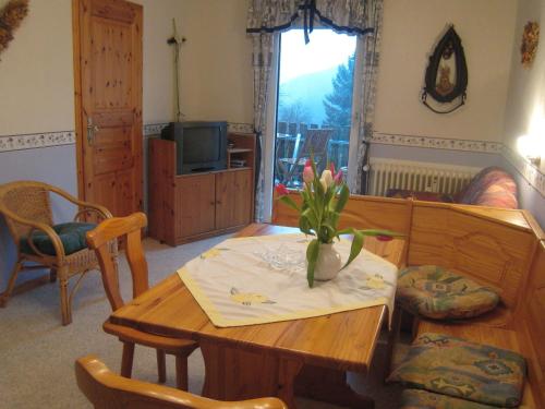 a living room with a table with a vase of flowers on it at Charming Apartment in Morbach Germany with Terrace in Thalfang