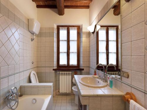 a bathroom with a sink and a tub and a toilet at Modern Holiday Home in Foiano della Chiana with Pool in Foiano della Chiana