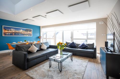 a living room with a black couch and a table at Temple Bar Crown Square Apartments in Dublin