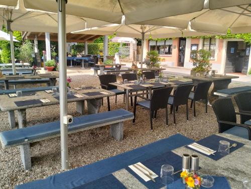 a group of tables and chairs with umbrellas at a restaurant at Villa Caslano in Caslano