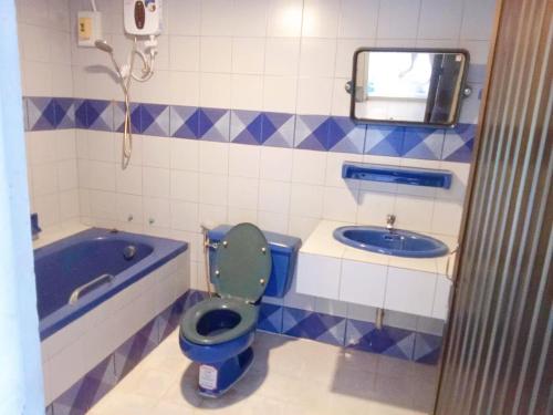 a bathroom with a blue toilet and a tub at Mitr Inn Phuket Oldtown in Phuket Town