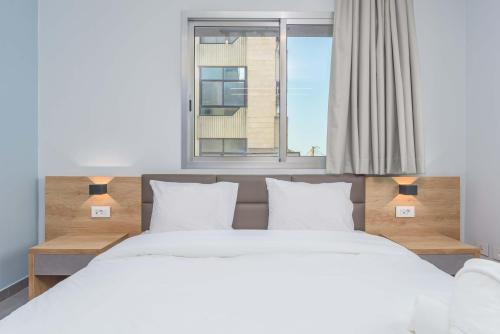 a bedroom with two beds and a window at Grey - Elegant Apartments in Awkar in Dbayeh