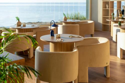 a restaurant with tables and chairs and a large window at INNSiDE by Meliá Alicante Porta Maris in Alicante