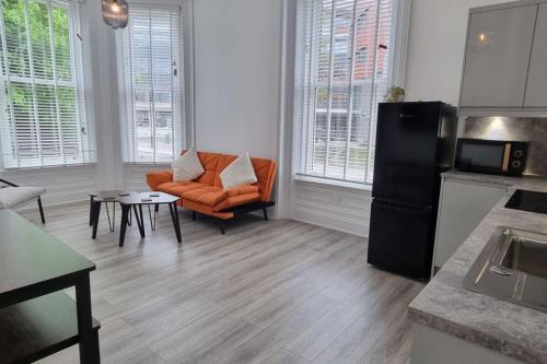 a living room with an orange chair and a couch at Tower House Apartments in Wakefield