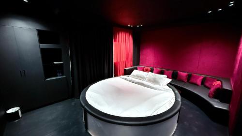 a bedroom with a bed with a red wall at Sunday Sharjah Aparthotel formerly Royal Tulip in Sharjah