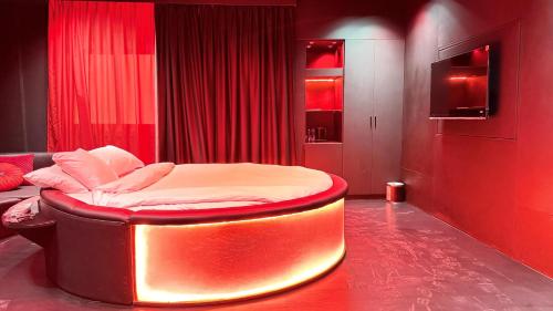 a bedroom with a bed in a red room at Sunday Sharjah Aparthotel formerly Royal Tulip in Sharjah
