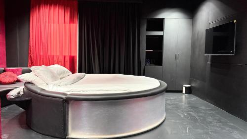 a circular bed in a room with a television at Sunday Sharjah Aparthotel formerly Royal Tulip in Sharjah