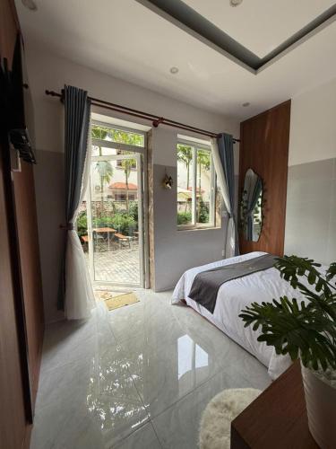 a bedroom with a bed and a large window at Wings House Homestay Hồ Tràm in Ho Tram