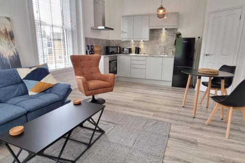 a living room with a blue couch and a table at Tower House Apartments in Wakefield