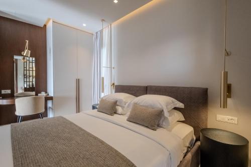 a bedroom with a large bed and a table at Maravilla Luxury Living in Kos Town