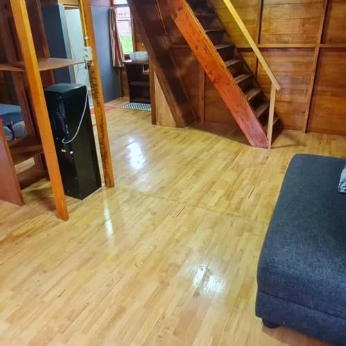 a living room with a wooden floor and stairs at Villa Kayu by Henery in Indarung