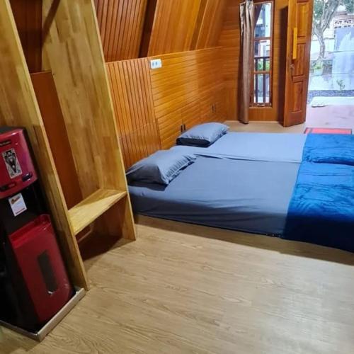 a bedroom with two beds in a wooden room at Villa Kayu by Henery in Indarung