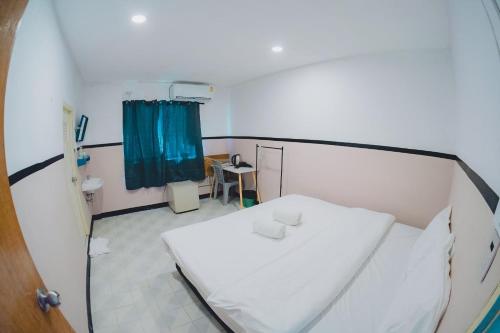 a hospital room with a white bed and a blue curtain at XX Mitr Inn Phuket Oldtown in Phuket