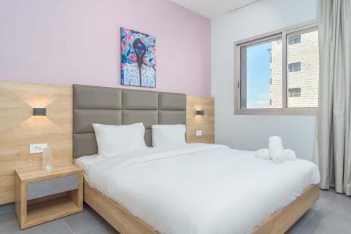 a bedroom with a large bed and a window at Grey - Elegant Apartments in Awkar in Dbayeh