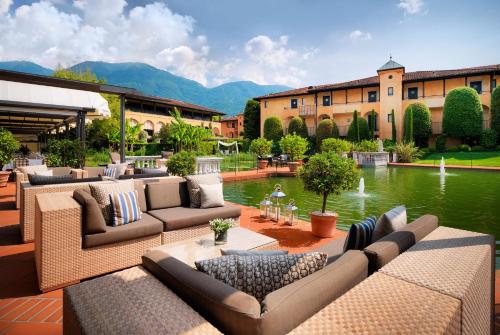 eine Terrasse mit Sofas und einem Teich vor einem Gebäude in der Unterkunft Giardino Ascona in Ascona