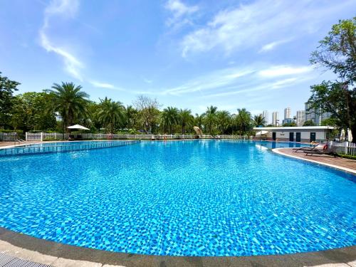 a large blue swimming pool with trees in the background at Great 2bedroom Apt Quick To My Dinh And Marriott Hotel, 30 Minutes To Airport in Hanoi