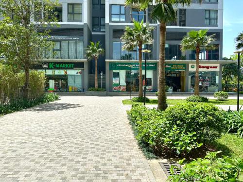 a sidewalk in front of a building with palm trees at Great 2bedroom Apt Quick To My Dinh And Marriott Hotel, 30 Minutes To Airport in Hanoi