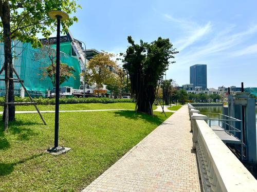 a sidewalk next to a park with a tree at Great 2bedroom Apt Quick To My Dinh And Marriott Hotel, 30 Minutes To Airport in Hanoi