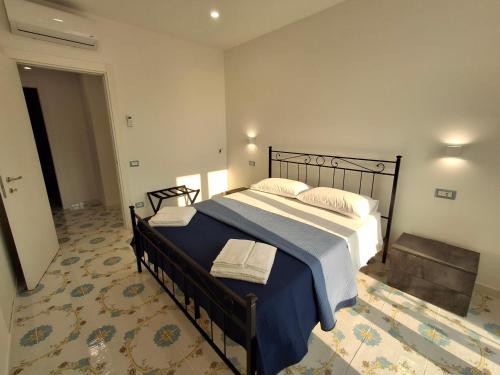 Un dormitorio con una cama grande con sábanas y almohadas azules. en Rosa House, en Termini