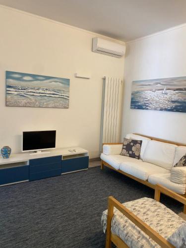a living room with a couch and a flat screen tv at Villetta mare e pineta in Fregene