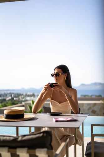 a woman sitting at a table taking a picture at Maravilla Luxury Living in Kos Town
