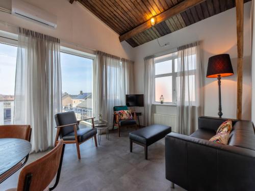 a living room with a couch and a table at Lovely, modern, 4-person apartment in the heart of Koudekerke in Koudekerke