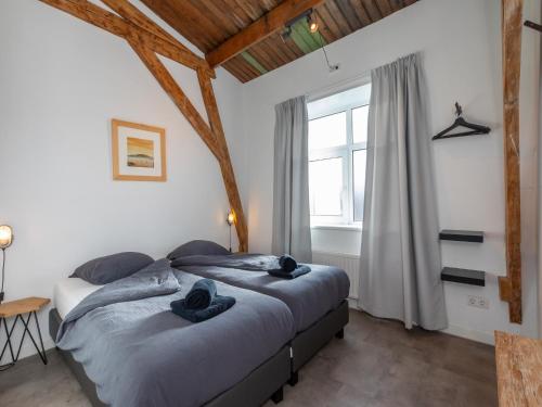 a bedroom with two beds and a window at Lovely, modern, 4-person apartment in the heart of Koudekerke in Koudekerke