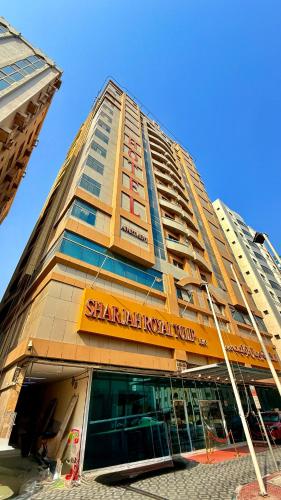 a tall building with a sign on the front of it at Sunday Sharjah Aparthotel formerly Royal Tulip in Sharjah