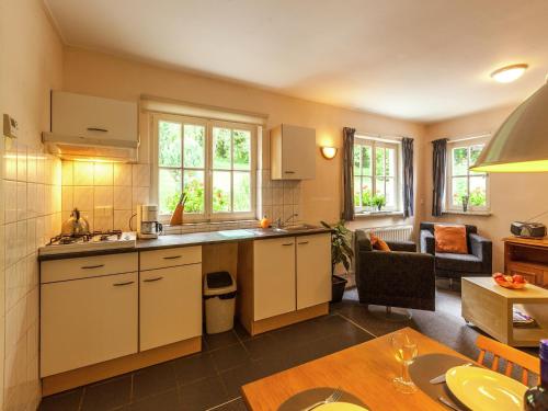 a kitchen and living room with a couch and a table at House situated on a magnificent estate in Barvaux