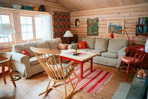 a living room with a couch and a table at Traditional Log Cabin At Reineskarvet in Ål