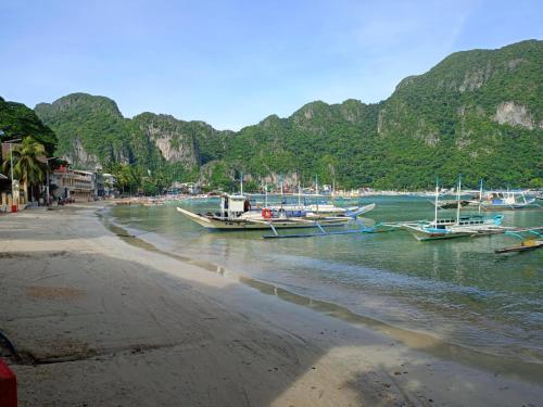 a group of boats docked on the shore of a beach at Cabugao Bed & Breakfast and Dorm in El Nido