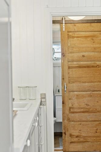 a bathroom with a wooden door and a sink at Authentic Wooden House With Wild Garden in Grevinge