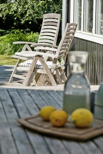 a plate of lemons on a table next to a chair at Authentic Wooden House With Wild Garden in Grevinge