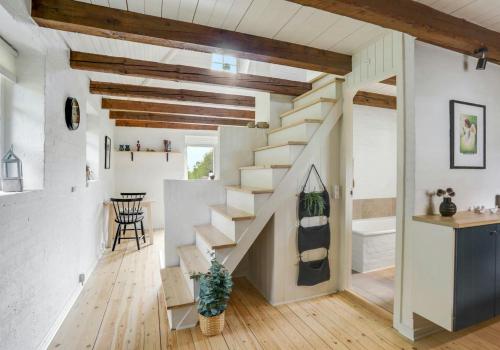 a staircase in a home with white walls and wooden ceilings at Sheena's Cabin In The Heart Of Hammer Bakker in Vodskov