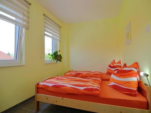 a bedroom with a bed with orange sheets and a window at Apartment Near Thuringian Forest in Tabarz