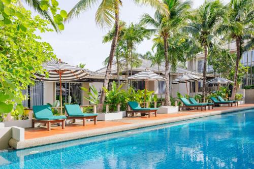 a pool at the resort with chairs and umbrellas at Signature Phuket Resort in Chalong